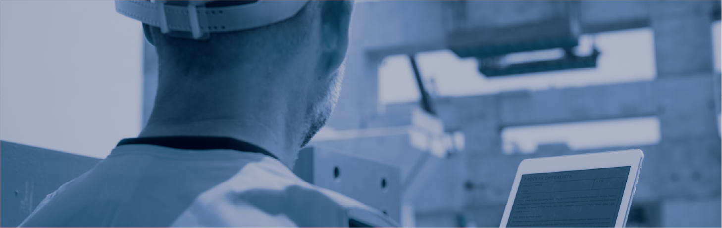 Inspektør i arbeidsklær sjekker komponenter på industriell installasjon og fører notater.